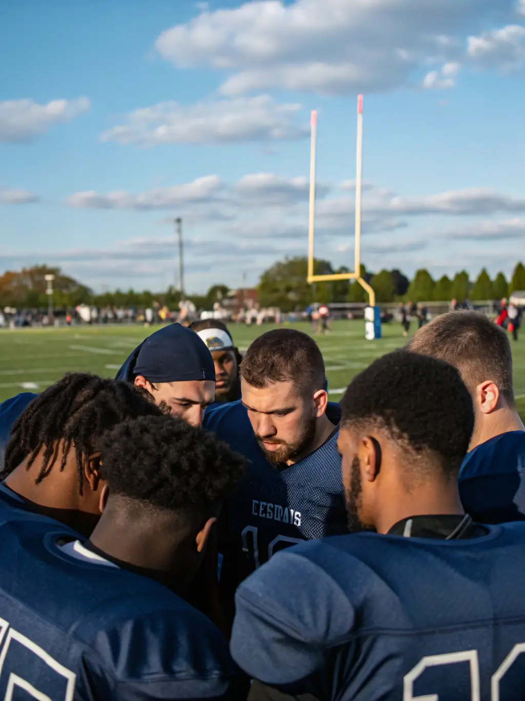 An image of a football team intensely reviewing plays on a tablet during a timeout, representing strategic email campaign planning.
